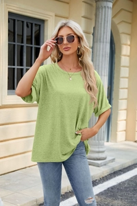 Close-up of a lime green crew neck T-shirt with drop shoulders on a stylish model