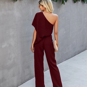 Women's burgundy off-shoulder high waist wide-leg jumpsuit with a stylish beige clutch bag