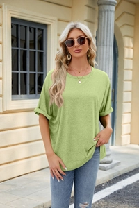 Detailed macro view of light green crewneck T-shirt showing rolled sleeve and cotton fabric