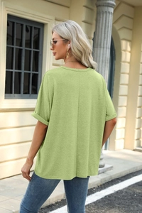 Detail of light green loose T-shirt featuring back vertical seam and cuffed sleeves