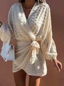 Détail de la robe portefeuille crème en jacquard à franges 3D avec décolleté en V