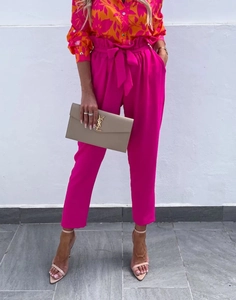 Detail of pink high-waist harem pants with tie-waist bow and lightweight floral shirt