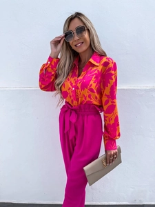 Detailed view of women's floral long-sleeve shirt paired with pink high-waist wide-leg pants