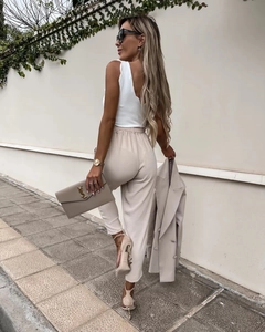 Chic street style featuring beige high-waist trousers and matching blazer with accessories