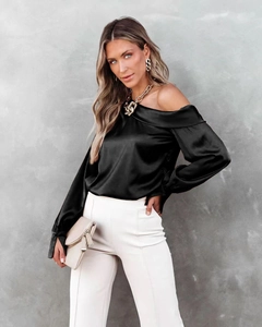 Close-up of elegant black satin off-the-shoulder blouse with silky sheen and long sleeves