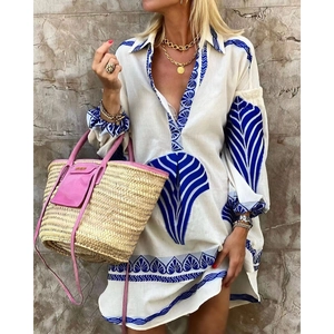 Women's white V-neck tunic shirt with blue leaf patterns and breezy lantern sleeves
