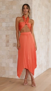 Λεπτομέρεια πορτοκαλί πλισέ σετ δύο τεμαχίων με τοπ halter και σατέν φούστα με στρίφωμα