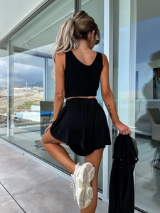 Vue arrière d'un ensemble jupe courte taille haute et débardeur court noir en ville