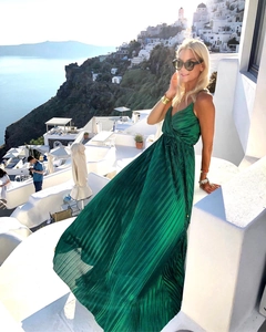 Detail of emerald pleated maxi dress with fine pleats and satin luster in sunlight