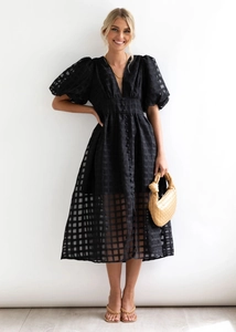 Detail of black puff sleeve dress with deep V-neckline and sheer checkered texture fabric