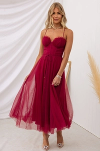 Detailed close-up of dark red tulle dress with corset bodice and delicate ruffle trim