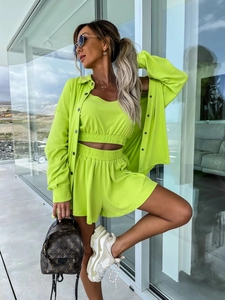 Détail de l'ensemble trois pièces vert néon montrant la texture tricotée et le short ample