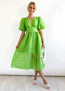 Detailed view of bright green plaid fabric texture and v-neck with puff sleeves