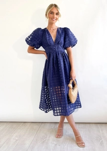 Detail of navy blue puff sleeve dress with textured checkered fabric and button accents