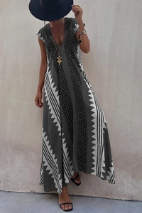 Détail de robe longue bohème gris foncé avec col en V et motifs géométriques blancs
