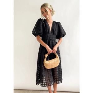 Fashionable black mid-length dress with puff sleeves, V-neckline and textured plaid fabric