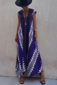 Détail d'une robe longue bohème violette et blanche avec col en V et motif géométrique