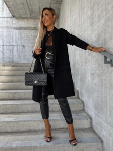 Dettaglio cappotto nero in lana dalla vestibilità comoda con leggings e borsa trapuntata
