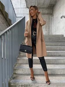 Dettaglio cappotto lungo color cammello con revers classico e tasche laterali con patta
