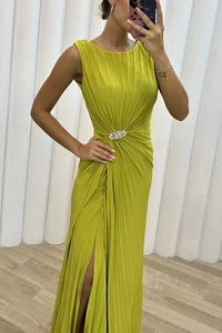 Detail of lime green pleated sleeveless dress featuring a crystal buckle and high slit