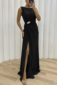 Detail of elegant black pleated sleeveless dress with rhinestone floral brooch and side slit