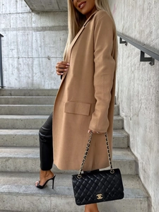 Vista dettagliata di un cappotto lungo in lana cammello con revers classici e tasche laterali