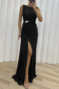 Detail of elegant black sleeveless evening gown featuring crystal brooch and side slit