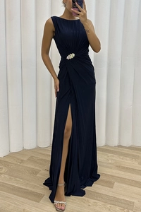 Detail of elegant navy sleeveless pleated dress featuring a colorful rhinestone waist buckle