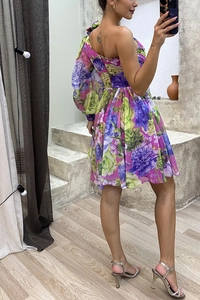 Detailed view of single shoulder floral print dress with lantern sleeve and pleated hem