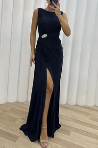 Detail of pleated sleeveless maxi dress with waist rhinestone flower and high side slit