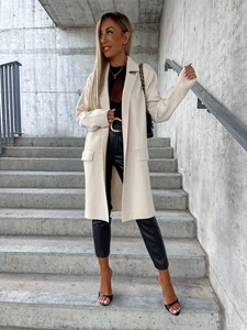 Dettaglio cappotto lungo in lana crema con rever classico e ampie tasche a patta