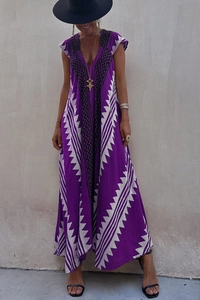 Détail de robe longue violette à col en V avec motifs géométriques et ourlet fluide