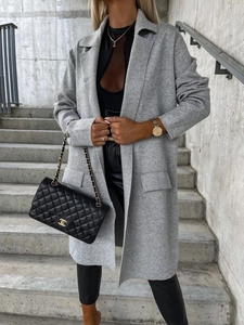 Dettagli del tessuto del cappotto in lana grigio chiaro con grandi baveri e tasche