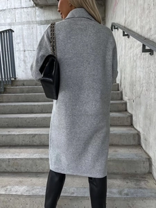 Vista posteriore di un cappotto lungo in maglia grigia con taglio dritto e cucitura dietro