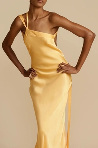 Detail eines eleganten One-Shoulder-Satin-Kleides in Gelb mit mehreren dünnen Trägern