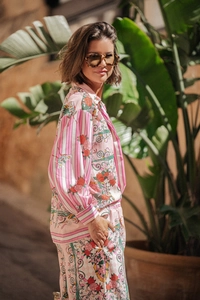 Outdoor view of women's pink floral two-piece set with long sleeve shirt and loose trousers