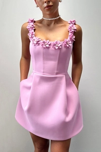 Close-up of pink sleeveless dress featuring 3D fabric flower details and hidden pockets