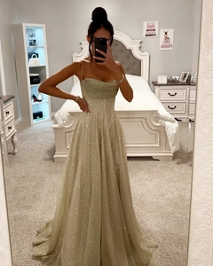 Détail de la robe longue à paillettes or champagne avec corsage et ourlet fluide