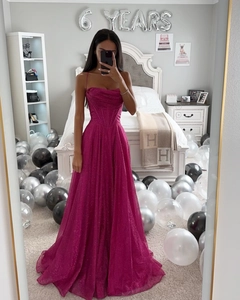 Détail d'une robe de soirée à paillettes avec fines bretelles et corsage en magenta