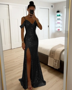 Détail d'une robe de soirée noire à paillettes avec épaules dénudées et fente haute