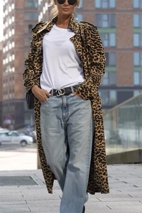 Detail eines Trenchcoats mit Leopardenmuster und Metall-Taillenschnalle an schicker Jacke