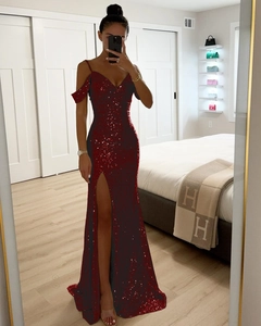 Détail d'une robe de soirée à paillettes rouges avec fines bretelles et fente latérale