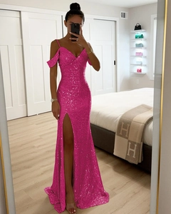 Gros plan sur une robe de soirée à paillettes fuchsia avec bretelles fines et fente haute