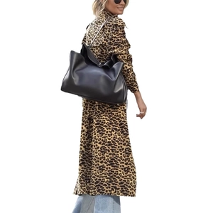 Schicke schwarze Oversize-Tasche aus Kunstleder, getragen zum modischen Leoparden-Mantel