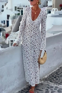 Dettaglio di abito lungo in pizzo bianco con scollo a V e motivi geometrici vuoti