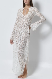 Dettaglio di un abito lungo in pizzo bianco con intricati motivi floreali traforati
