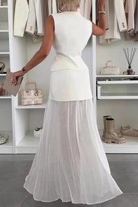 Dettaglio del top bianco in maglia e dell'elegante gonna lunga in tulle plissettato