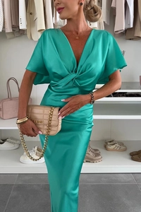 Détail de la robe en satin vert émeraude avec taille torsadée et manches chauve-souris