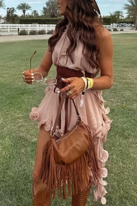 Close-up of brown pebbled leather crescent bag with long tassels and boho fringe detail
