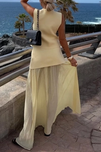 Vista posteriore di un set da resort con gilet in maglia giallo chiaro e gonna lunga